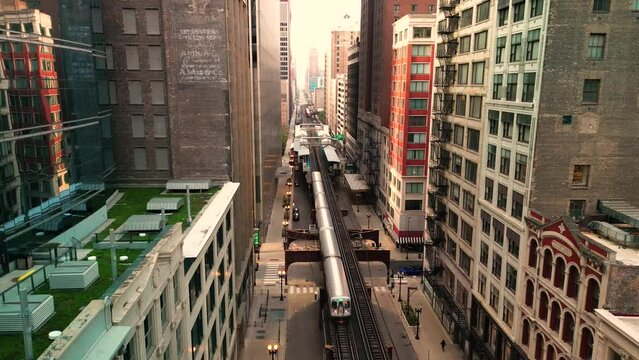 Aerial descent of elevated metro train through downtown Chicago