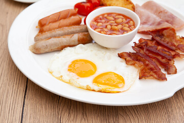 Full English breakfast set with sausage, egg, bacon, baked bean, ham, tomato and toast