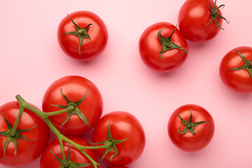 Flat lay composition with bunch of tomatoes on pink background. Space for text