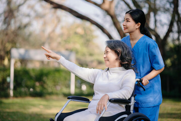 Obraz premium Asian young caregiver nurse support senior older male walking outdoors. Specialis doctor help and take care of elderly mature.