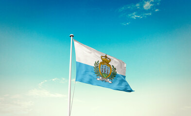 Waving Flag of San Marino in Blue Sky. The symbol of the state on wavy cotton fabric.