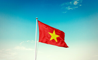 Waving Flag of Vietnam in Blue Sky. The symbol of the state on wavy cotton fabric.