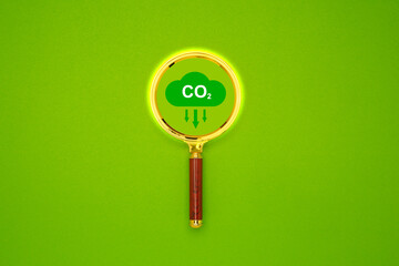Reduce CO2 emission icon inside the magnifier glass for focusing decrease CO2 or carbon dioxide emission.