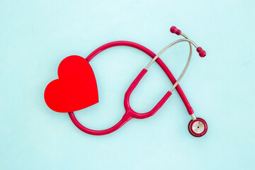 Cardiology and insurance concept with red heart and medical stethoscope