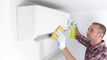 Service guy cleaning and maintaining air condition unit.