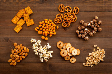 Set of different salty snacks - chips popcorn and nuts. Fast food background