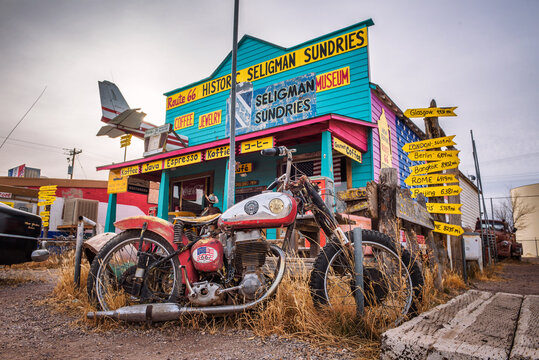 Seligman, Arizona, USA - January 2, 2018 : Vintage motorbike left abandoned in front of a souvenir shop on historic route 66 in Arizona.