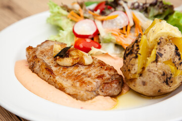 Pork sirloin steak with baked potato and andalouse sauce