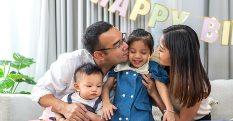 Portrait of enjoy happy love asian family father and mother holding hug cute little asian girl child smiling play and having fun moments good time in at home