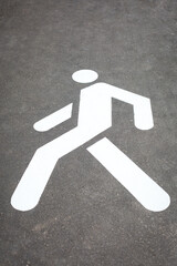 White sign on asphalt footway, safe road. Sign indicates place for safe traffic people. Summer sunny day. Selective focus. Close-up. Vertical.