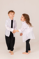 Cheerful and happy boy and girl brother and sister having fun on white background. Black and white style