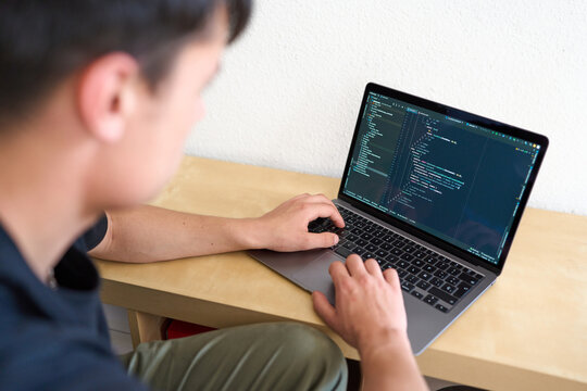 Guy using a laptop to program code.