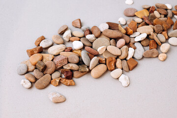Natural background. Different pebbles on a gray concrete background. Sea stones of different colors. Background for design