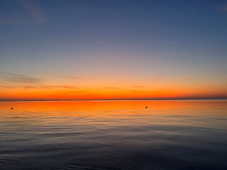 Orange sea horizon, seascape after the sunset, orange sunset reflection