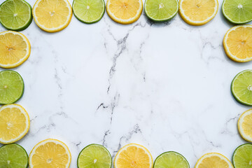 Citrus background, lemon and lime on a marble backdrop, copy space, summer frame background, fresh and juicy, fruit composition, table