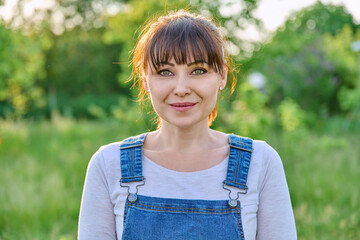 Outdoor headshot portrait of mature smiling woman in countryside