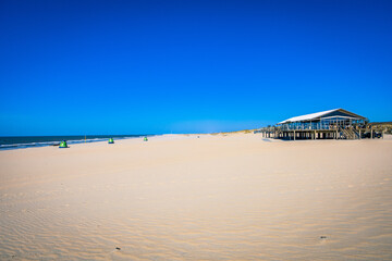 A Cafe in the Foreground of a Sunny Day at the Yellow Sand Beach near The Hague