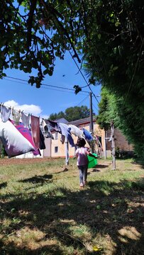 Ni&ntilde;a en campo tendiendo ropa
