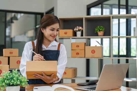 Business From Home Asian woman preparing package delivery box Shipping for shopping online. young start up small business owner at home online order