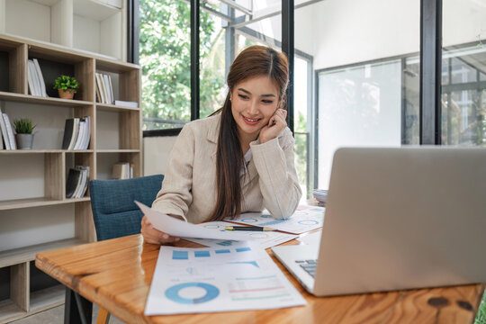 Asian businesswoman sit at their desks and calculate financial graphs showing results about their investments, plan a successful business growth process