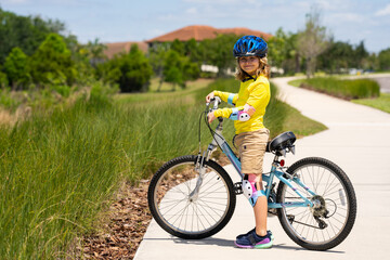 Boy in a helmet riding bike. Boy in safety helmet riding bike in city park. Child first bike. Kid...