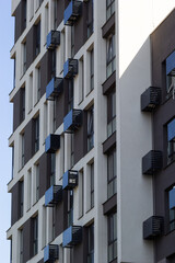 Architectural details of modern high apartment building facade with many windows and balconies