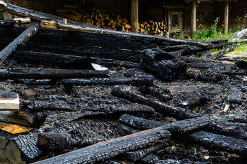 Destroyed by fire wooden house completely burned to the ground .ruins of a burnt wooden house after a fire