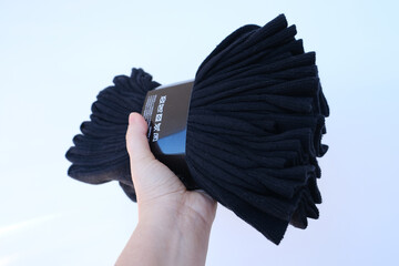 large pack of new men's black socks in female hand, concept gift for the day father, socks are...