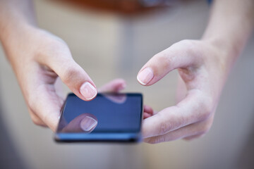 Hands, phone and communication with a woman typing a text message closeup on a blurred background. Mobile, networking and social media with a female person reading a text or browsing alone outdoor