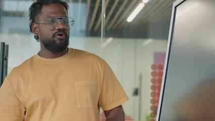 PAN shot of man giving business presentation to multi-ethnic gen Z coworkers on office meeting