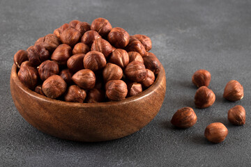 View of a bowl full of hazelnuts on a black background
