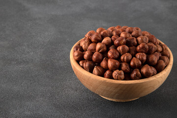View of a bowl full of hazelnuts on a black background