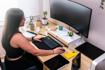 Seamless Programming: Young Female Coder Excels in Home Workspace Setup