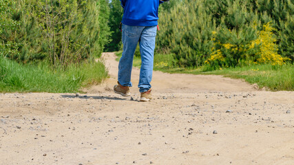 Chłopak spacerujący polną drogą w niebieskim ubraniu