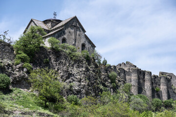 Fototapeta premium ancient temple and the ruins of the fortress wall in the mountains of Armenia