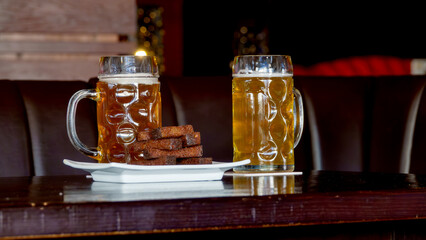 Two glasses of light beer stand on a table
