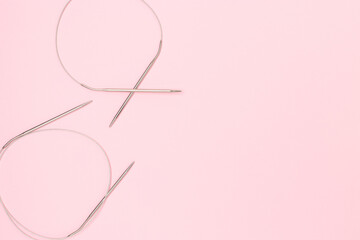 Knitting needles on a pink background. Hobby accessories with place for text.