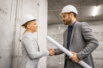 Architect shaking hands with construction engineer for successful cooperation.