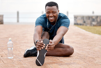 Stretching legs, fitness and portrait of black man in park for exercise, marathon training and running. Sports, music and male person stretch for warm up, workout and listen to audio for wellness