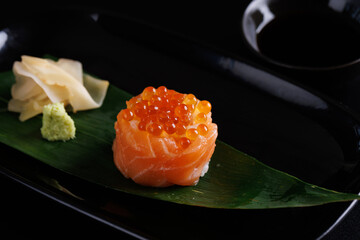Salmon Sushi roll with caviar topping Japanese food isolated in black background