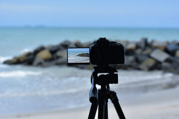 The camera is on a tripod at the seashore.