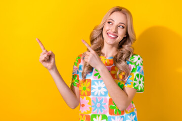 Photo of interested cute lady direct fingers empty space advise novelty banner wear floral shirt isolated yellow color background