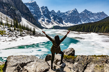 Woman tourist backpacker viewing the beautiful landscape of banff national park. Icy mountains. Tourist hiking. With open arms.