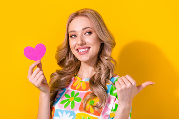 Photo of pretty lady girlfriend hold little paper heart direct finger banner lovers day party event isolated yellow color background