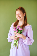 Beauty portrait of pretty young 15 - 16 year old redhaired teeenage girl wearing purple dress...
