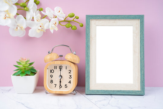 The Blank picture frame and alarm clock on black floor with copy space and clipping path for the inside.