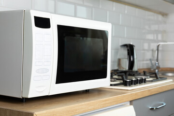 Fototapeta premium Modern microwave oven in the kitchen. Interior of kitchen with modern microwave oven. Cooking food. Space for text.Space for copy. Close-up.