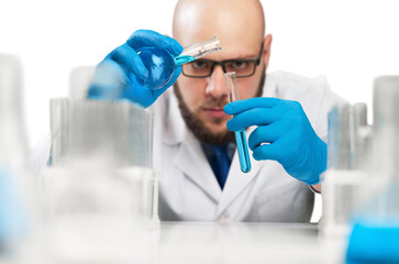 Male researcher carrying out scientific research in a lab with glassware