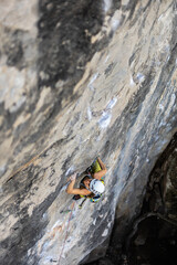 woman climbing big walls in the mountains, doing sports, striving hard for her goals without fear of success, courageous person, confident person with commitment.