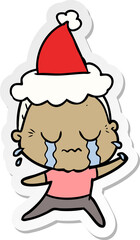 hand drawn sticker cartoon of a crying old lady wearing santa hat